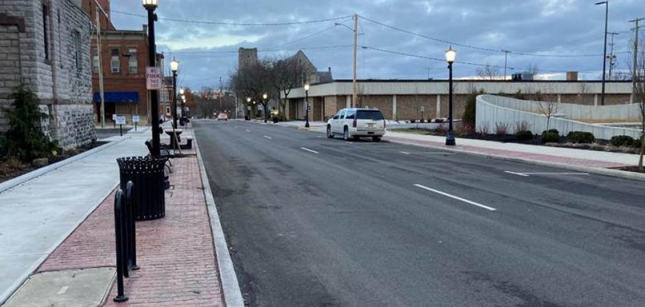 A newly paved road with street lights, sidewalk and decorative street lights