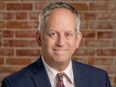 Photo of Councilman John Kahler. Man sitting in front of brick wall.