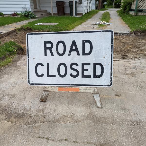 A white sign indicates that a road is being closed for construction