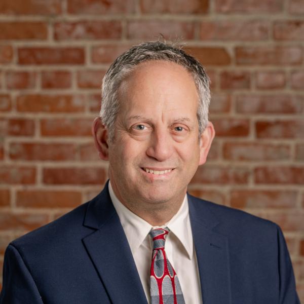 Photo of Councilman John Kahler. Man sitting in front of brick wall.